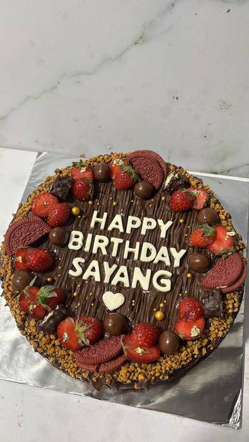 Brownies hias bulat dengan strawberry segar dan tulisan coklat
